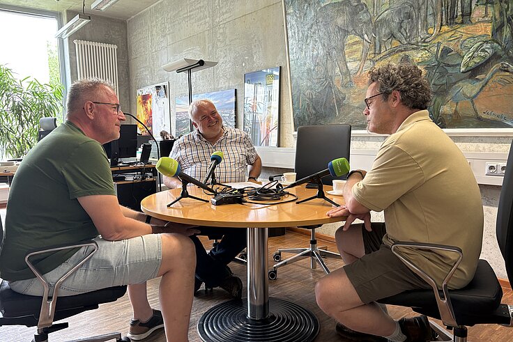Im Podcastgespräch Michael Ernst und Jörg Junhold Zoodirektor, Tierpfleger und Moderator sitzen in einem Büro am Tisch und plaudern